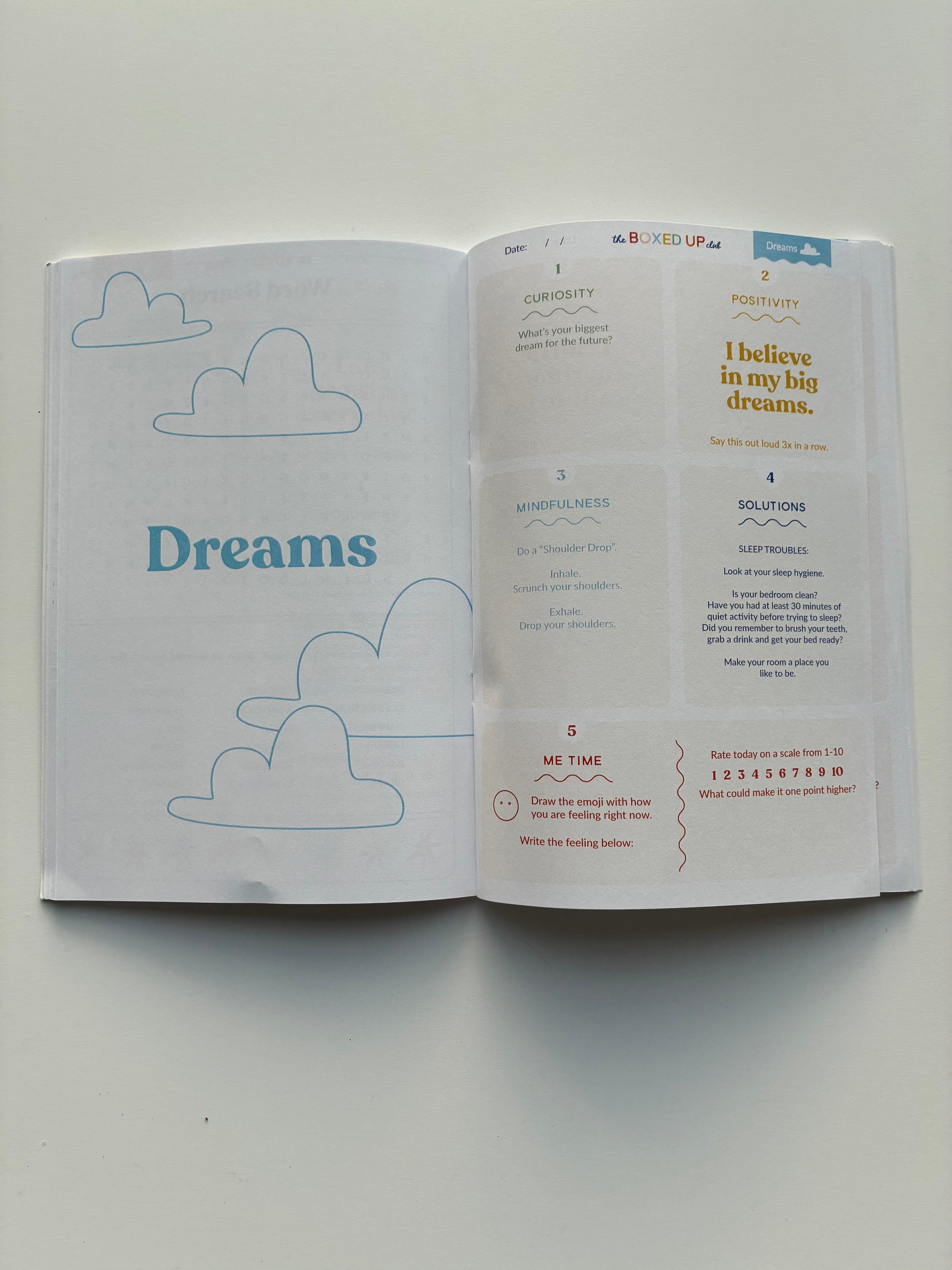 Open book with cloud illustrations and 'Dreams' text on a light gray background